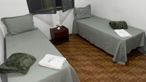 a room with two beds and a table at Casas de Temporadas - Hotel Recanto do Sossego in Uberlândia