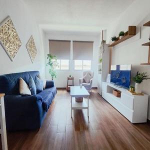 a living room with a blue couch and a table at Escapada Deluxe con Wifi 2 Hab 2 Baños con Cocina & SmartTV cerca de Todo in Santa Cruz de Tenerife +15 photos