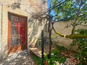 a house with a door and a tree in front of it at Appartement à la campagne in Saint-Savin