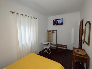 a bedroom with a yellow bed and a chair at AL - Casa 42 in Monção