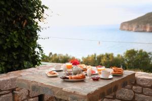 a table with breakfast foods and drinks on top of a wall at Panorama Rooms in Pirgos Dhirou +34 photos