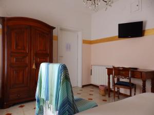 a room with a chair and a desk and a television at Sa Chessa B&B in Ploaghe