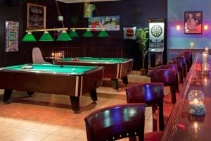 a row of pool tables in a bar with chairs at Grand Hotel Ocean City Oceanfront in Ocean City