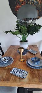 a wooden table with plates and a potted plant at De Bosuil in Putten +30 photos