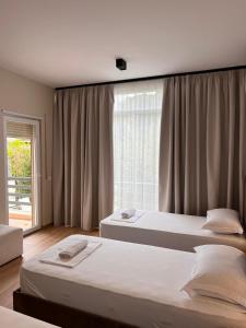 Apartment Gjiri i Lalzit في دوريس: سريرين في غرفة بها نافذة