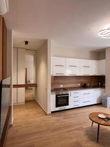 Apartment Gjiri i Lalzit في دوريس: مطبخ فارغ مع دواليب بيضاء وطاولة