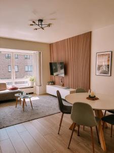 una sala de estar con una mesa, sillas y un sofá en Vitamin Sea, in het centrum en naast de zee, en Ostende