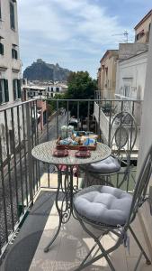 a table and chairs on a balcony with a view of a city at B&B A Due Passi in Ischia Town