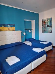 two beds in a room with blue walls at B&B Museum in Naples