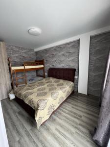 une chambre avec un lit et un mur en pierre dans l'établissement Borjomi house Robakidzis 5g Borjomis national park Borjomis cultural monuments, à Bordjomi