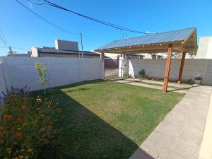 a backyard with a wooden pergola and a fence at Alquiler Temporal Tandil - Xavier in Tandil