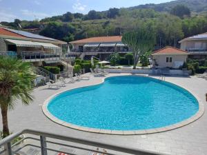 ein großer Swimmingpool in einem Resort mit Stühlen und Bäumen in der Unterkunft Villa VAdel Zambrone Marina in Zambrone + 29 Fotos