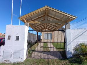 a building with a gate with a wooden roof at Alquiler Temporal Tandil - Xavier in Tandil