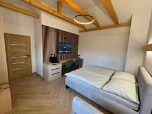 VarínにあるDaily Living - Apartmán v centre Varína, Free Parkingのベッドと机とテレビのある寝室 +20枚の写真