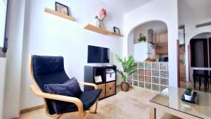 a living room with a chair and a television at Loft céntrico en Ronda cercano al Tajo y Plaza de Toros con Wifi y Parking Opcional in Ronda