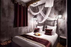 Schlafzimmer mit einem großen Bett mit roten Wänden in der Unterkunft Hôtel Cap Pirate in Cap d'Agde