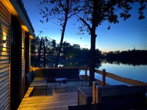 a porch of a house with a bench and a lake at Sea-Lodge, direkt am See, Tiny House in Dessau