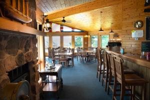 a dining room with a bar and tables and chairs at Square Rigger Lodge in Jacksonport
