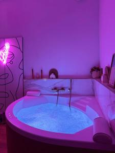a bathroom with a tub with purple lighting at Mini loft Spa - Cosy in Dijon