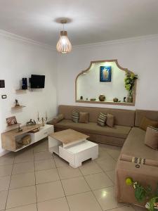 a living room with a couch and a table at Maison Chkili in Kelibia +17 photos
