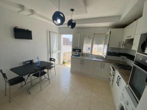a kitchen with a table and a table and chairs at Maison Chkili in Kelibia