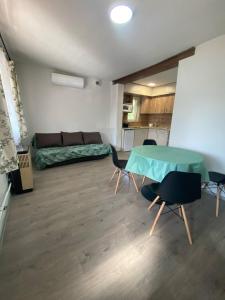 a living room with a table and chairs and a couch at Pompa Apartman in Nyíregyháza