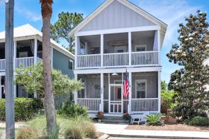 Casa blanca con porche y bandera en Barefoot Cottage B12 - Sea La Vie by Pristine Property Vacation Rentals, en Highland View