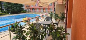 阳光海滩Rainbow 2 studio 7的游泳池旁带桌椅的阳台