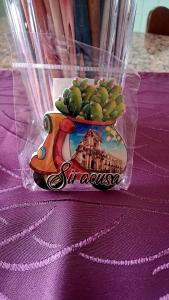 a vase with a bunch of green fruits on a table at Casa di Angela in Siracusa
