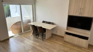 a living room with a table and chairs and a television at Casa Luca in Carvoeiro