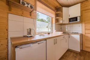 a kitchen with white cabinets and a window at Bieszczadzki Zakątek 787-899-185 in Bukowiec