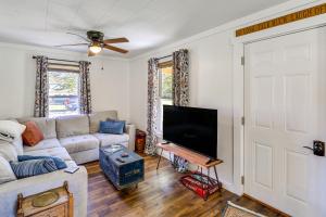 a living room with a couch and a flat screen tv at Walk to River and Trails Cozy Damascus Cottage! in Damascus