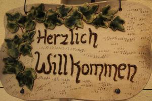 a sign that says harrietiveduminati with green leaves on it at Ferienwohnung Hochwaldblick in Hörnitz