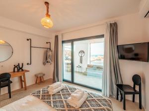 a bedroom with a bed and a window and a desk at Shark Luxury Villa in Agios Ioannis Mykonos +16 photos