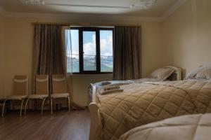 una camera da letto con un letto, due sedie e una finestra di Aspet B&B a Tatev