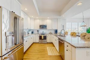 een keuken met witte kasten en roestvrijstalen apparaten bij Dolphin's Cove - Clearwater Beach, FL in Clearwater Beach