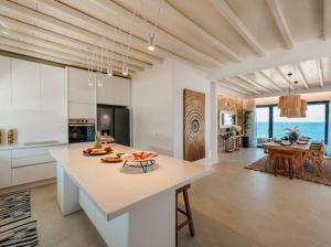 a kitchen with a island in a room with the ocean at Shark Luxury Villa in Agios Ioannis Mykonos