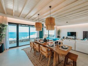 a dining room with a table and a view of the ocean at Shark Luxury Villa in Agios Ioannis Mykonos