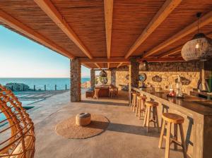 a kitchen with a bar with a view of the ocean at Shark Luxury Villa in Agios Ioannis Mykonos