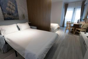 ein Schlafzimmer mit einem großen weißen Bett und einem Tisch in der Unterkunft Hedarom Eforie in Eforie Nord