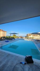 a large blue swimming pool in a building at Mediterraneo Suites with Pool & Sea View Escape in Nea Kalikratia