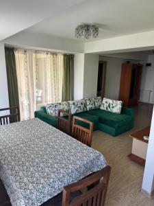 ein Wohnzimmer mit einem grünen Bett und einem Sofa in der Unterkunft VIRGO Apartaments Mamaia in Mamaia