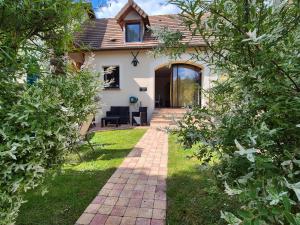 una casa con una pasarela de ladrillo en el patio en L'Abaca 23, en Sainte-Geneviève-lès-Gasny