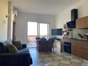 kuchnia i salon z kanapą i stołem w obiekcie Casa Cappello w mieście Lecce