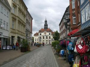a city street with a building with a clock tower at 1-bedroom apartment in Amelinghausen