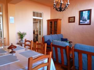 a dining room with a table and blue chairs at La casa de Don Juan in Puntallana