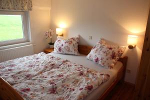 a bedroom with a bed with a floral bedspread and pillows at Ferienwohnung Koitscheblick in Hörnitz