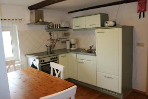 a kitchen with a white refrigerator and a table at Ferienwohnung Koitscheblick in Hörnitz