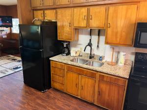 a kitchen with a black refrigerator and a sink at Emma's Cottage #537 in Sevierville
