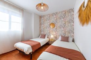 two beds in a room with a wall at Jardín privado # NETFLIX # Playa a 8min # WIFI # Familia # Apartamento in Vera